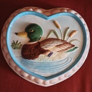 Vintage heart-shaped yellow mold with the duck in cattails sitting in the pond.